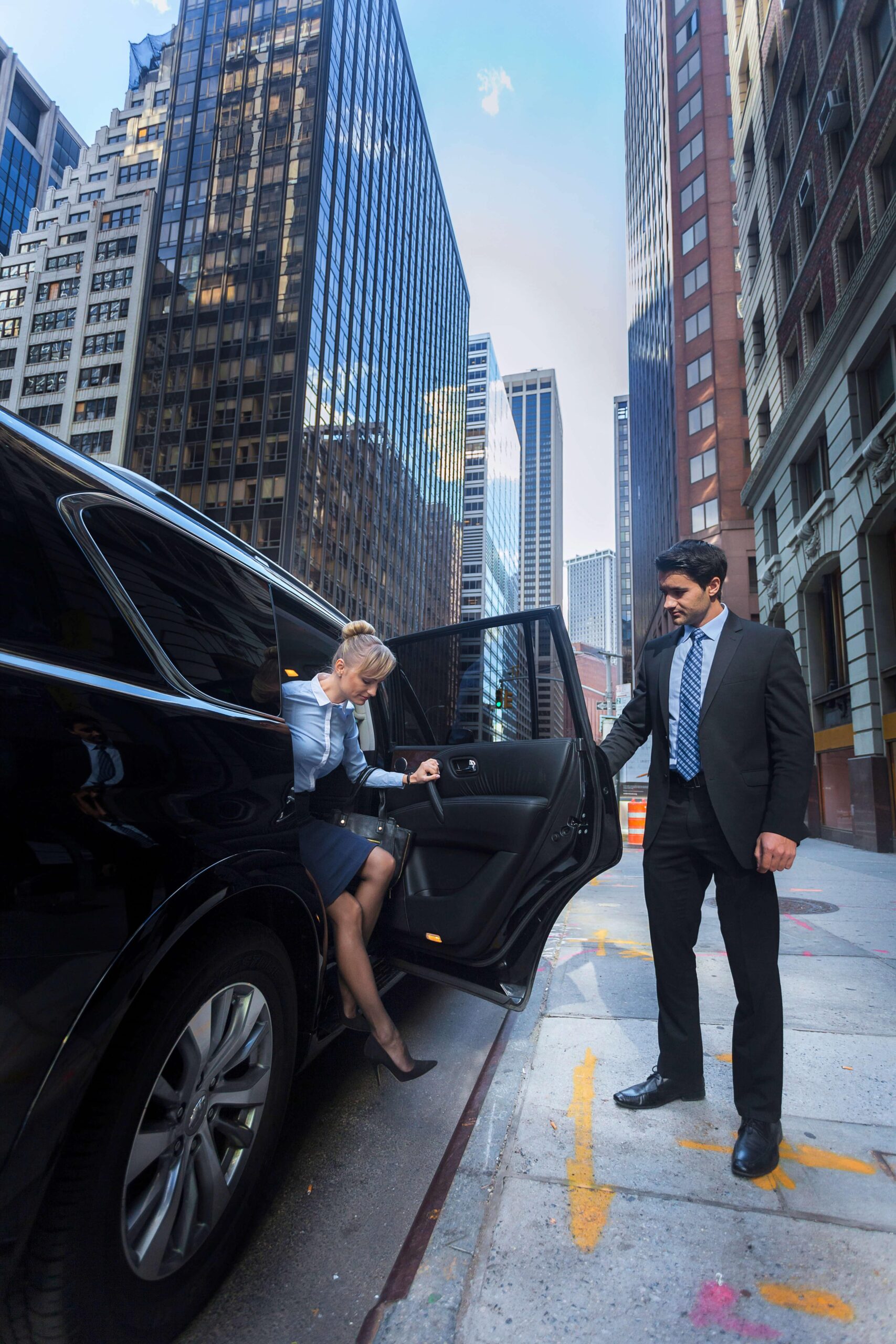 A driver is opening gate of a Limo for her client showing corporate limo service
