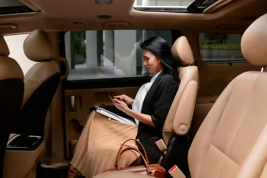 A passenger works from the back seat of a chauffeur-driven sedan during a day at her disposal in Paris A passenger works from the back seat of a chauffeur-driven sedan during a day at her disposal in Paris