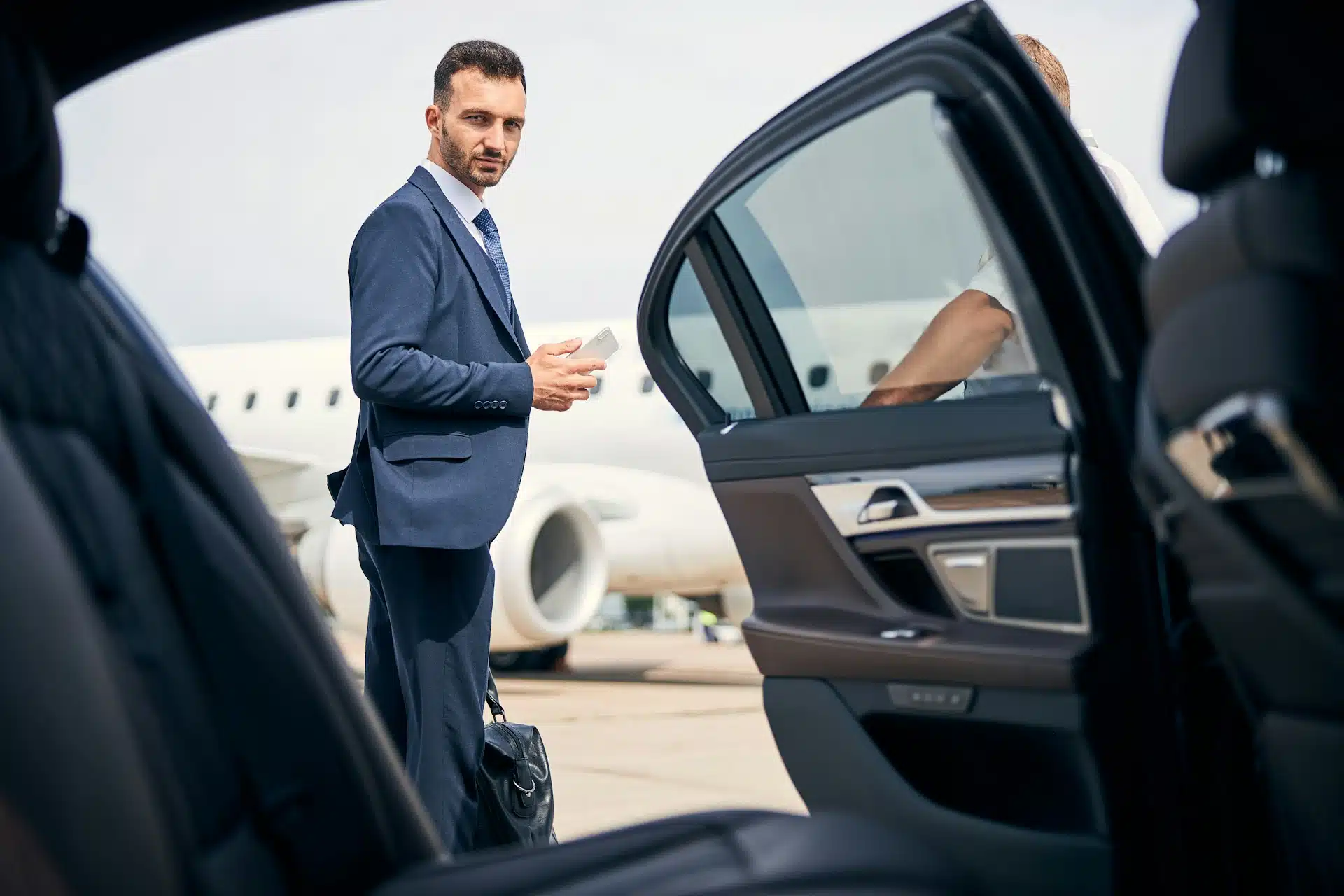 Private chauffeur opening the car door for a client